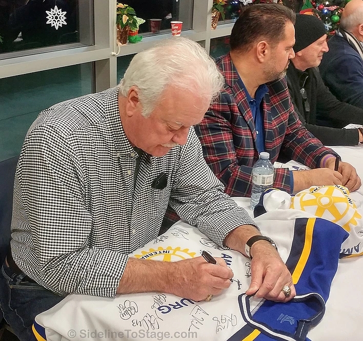 Habs legend, Yvon Lambert adds his signature to a jersey.